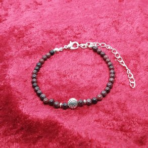 Flot armb�nd med m�rke tiger�jne, og med charms. F�s i 3 st�rrelser